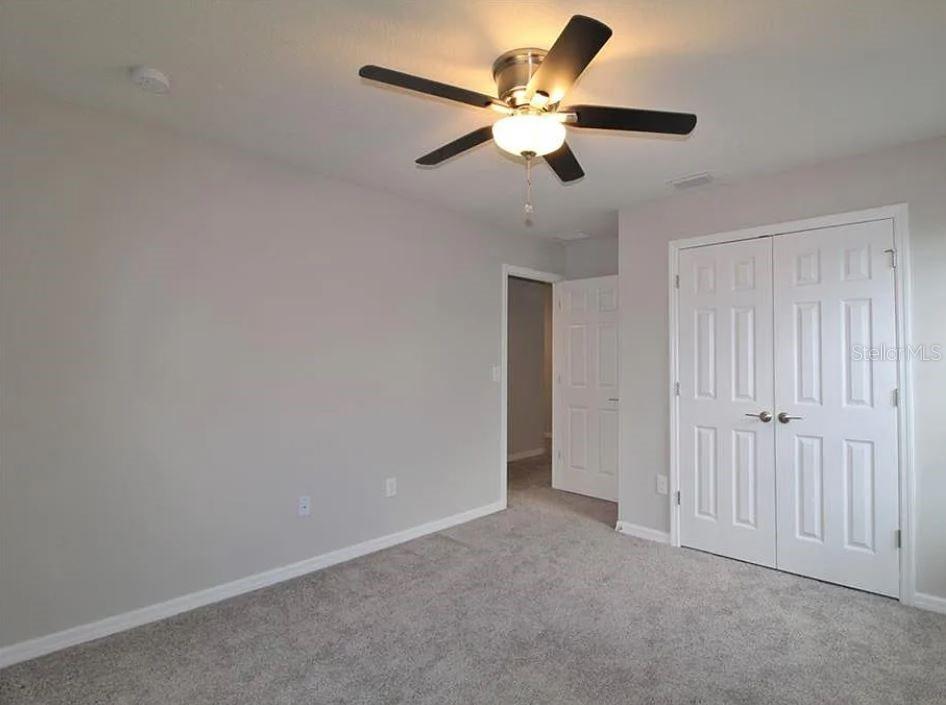 1049 Multiflora Loop Lutz, FL 33558 - Photo 22 of 49 an empty room with a ceiling fan and a window