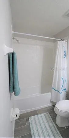 a bathroom with a granite countertop sink and a toilet