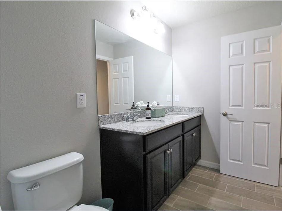 1049 Multiflora Loop Lutz, FL 33558 - Photo 28 of 49 a bathroom with a granite countertop sink and a toilet
