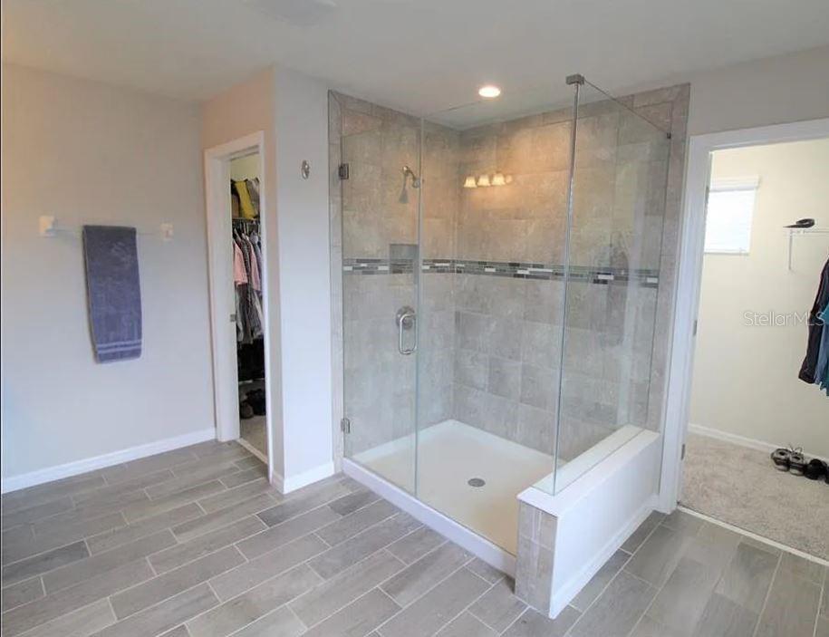 1049 Multiflora Loop Lutz, FL 33558 - Photo 35 of 49 a bathroom with a tub shower a mirror and a shower