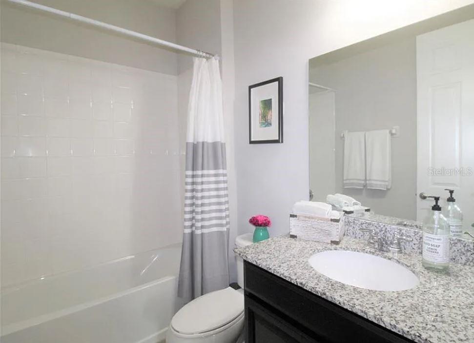 1049 Multiflora Loop Lutz, FL 33558 - Photo 6 of 49 a bathroom with a granite countertop sink mirror vanity and toilet