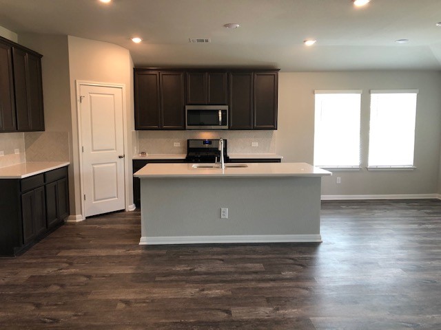 1237 Oak Chase Way Leander, TX 78641 - Photo 5 of 19 a kitchen with stainless steel appliances granite countertop a sink a stove a refrigerator cabinets and a kitchen island