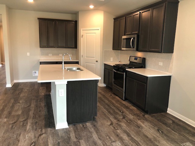 1237 Oak Chase Way Leander, TX 78641 - Photo 7 of 19 a kitchen with stainless steel appliances granite countertop a sink stove and refrigerator