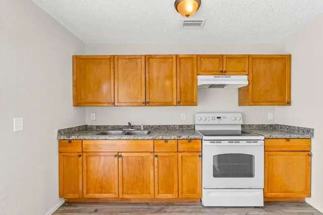 a kitchen with a sink cabinets and a wooden floor