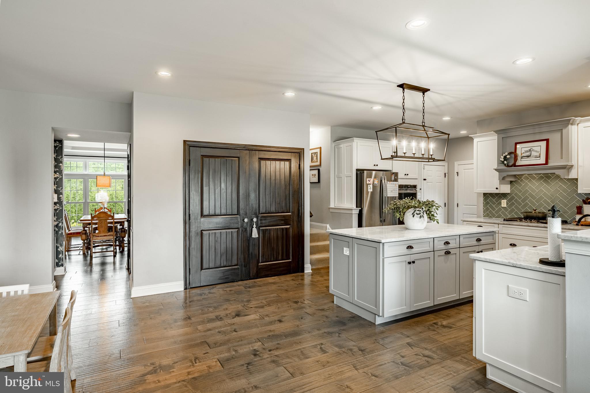 2084 Flowing Springs Road Chester Springs, PA 19425 - Photo 21 of 73 a kitchen with stainless steel appliances a refrigerator a stove a sink a dining table and chairs