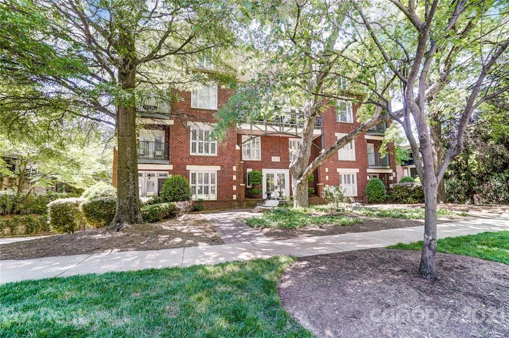 416 Queens Road Charlotte, NC 28207 - Photo 23 of 25 a view of a big yard in front of a brick house with large windows