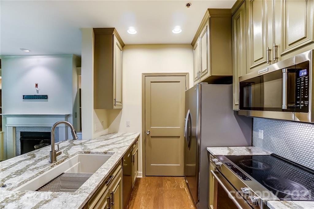 416 Queens Road Charlotte, NC 28207 - Photo 7 of 25 a kitchen with stainless steel appliances granite countertop a refrigerator a stove and a sink with wooden floor