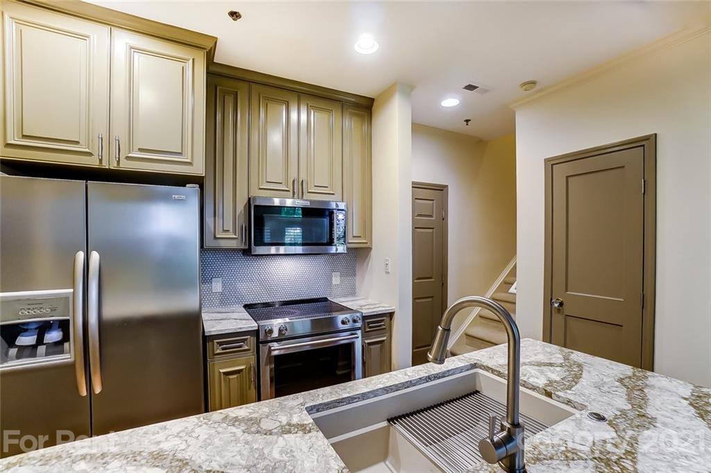 416 Queens Road Charlotte, NC 28207 - Photo 8 of 25 a kitchen with granite countertop a refrigerator and a stove top oven