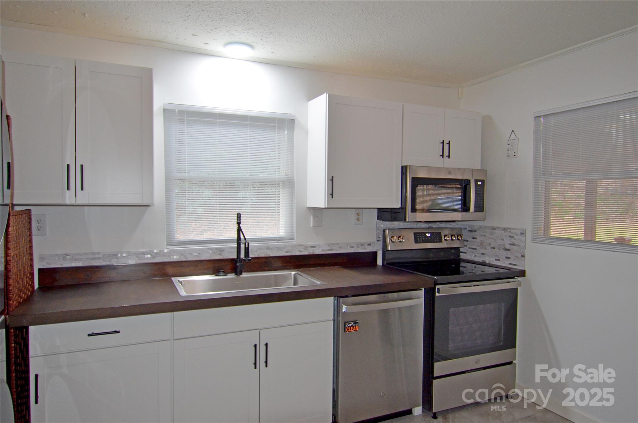 93 John Gilkey Road Marion, NC 28752 - Photo 8 of 13 a kitchen with sink a microwave a stove and cabinets