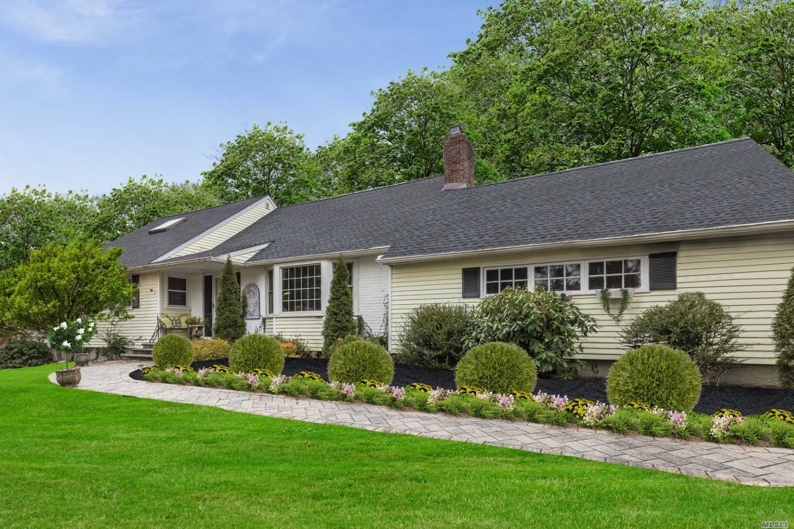 a front view of a house with a yard and potted plants
