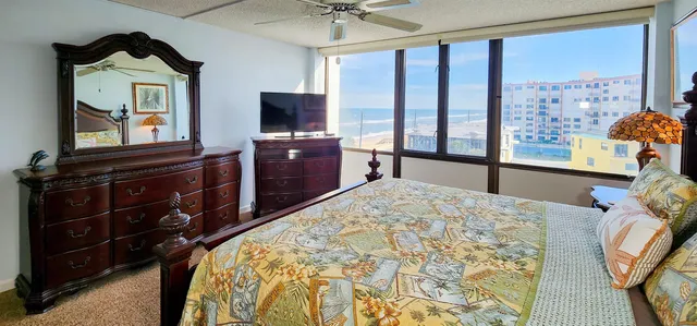 a bedroom with a bed and a flat tv screen on dresser