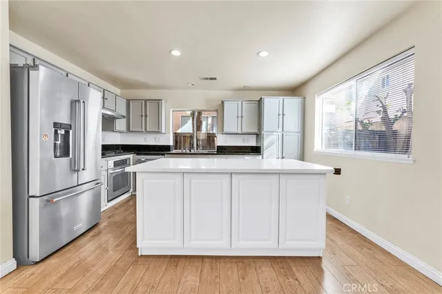 a kitchen with stainless steel appliances a refrigerator and a stove top oven