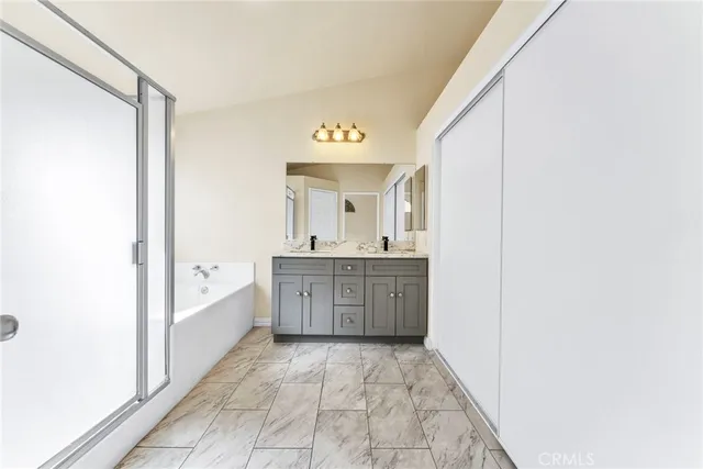 a spacious bathroom with a bathtub sink and mirror