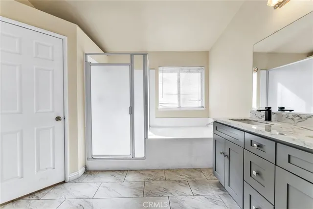 a bathroom with a granite countertop sink a mirror and a bathtub