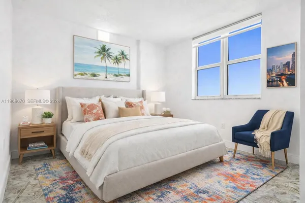 a bedroom with a bed a chair and painting on the wall