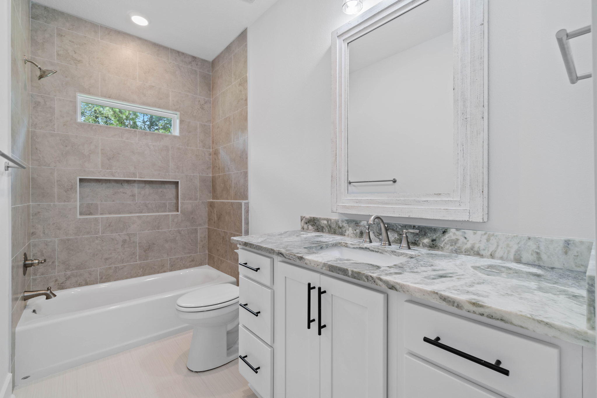 6949 Snug Waters Road Navarre, FL 32566 - Photo 35 of 51 a bathroom with a granite countertop toilet a sink and bathtub