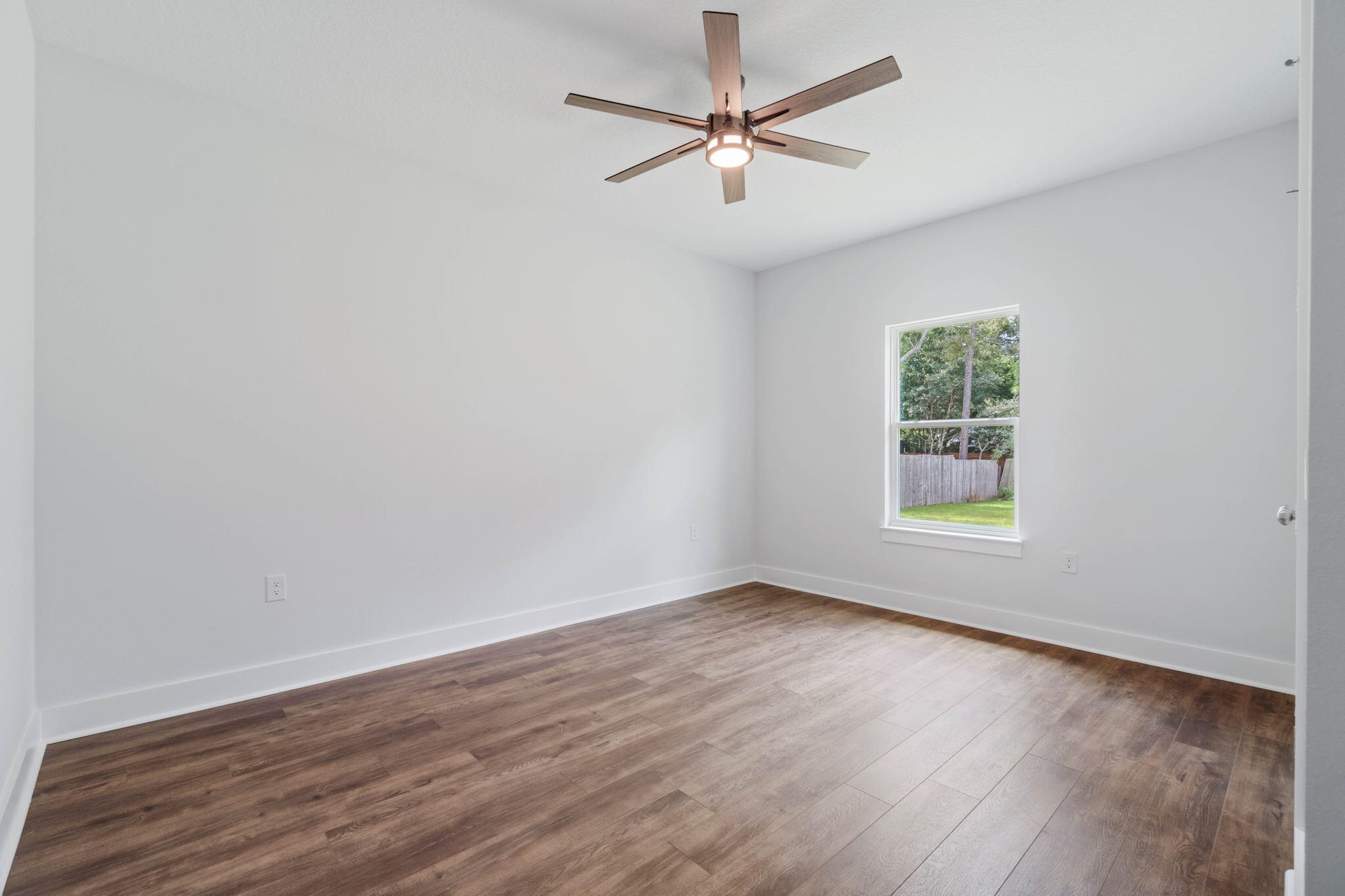 6949 Snug Waters Road Navarre, FL 32566 - Photo 36 of 51 an empty room with wooden floor and windows