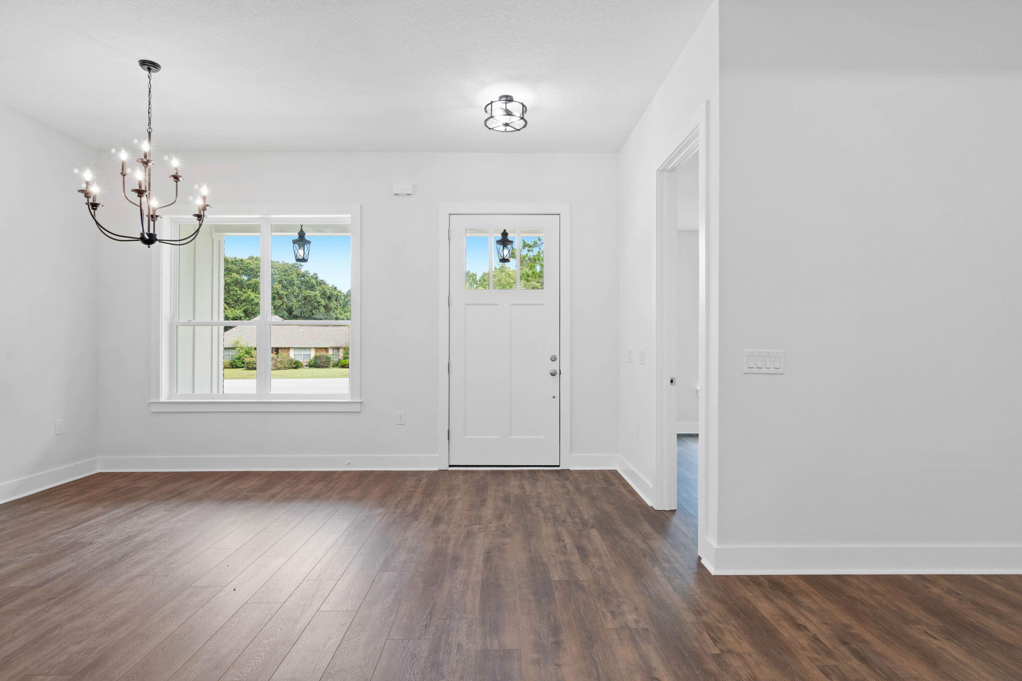 6949 Snug Waters Road Navarre, FL 32566 - Photo 7 of 51 an empty room with wooden floor chandelier and windows