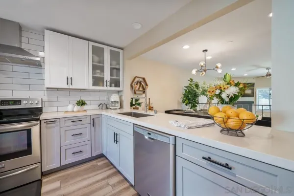 a kitchen with a sink white cabinets and white appliances