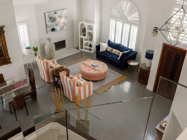 a living room with furniture a fireplace and a floor to ceiling window