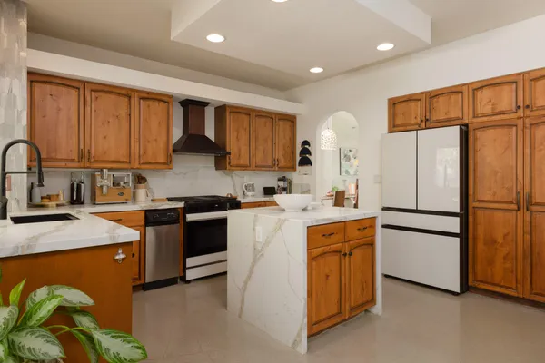 a kitchen with a refrigerator sink and cabinets