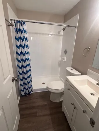 a bathroom with a sink a toilet and shower