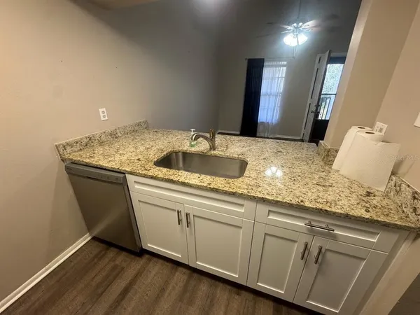 a bathroom with a granite countertop sink and white cabinets