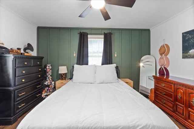 a bedroom with a bed and a flat tv screen on dresser