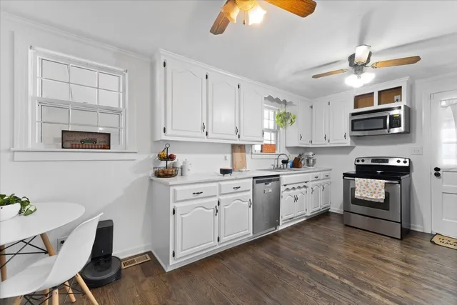 a kitchen with stainless steel appliances a refrigerator sink and white cabinets
