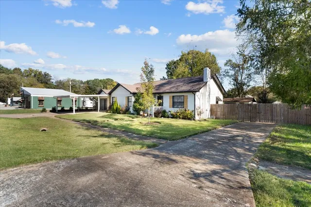 a view of a house with pool and chairs next to yard