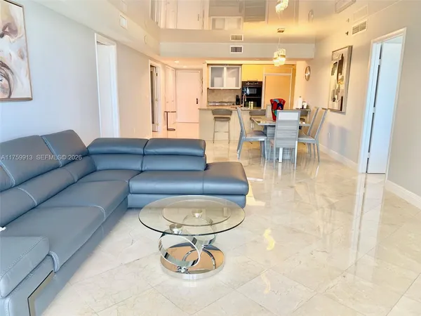 a living room with furniture a dining table and chairs with kitchen view