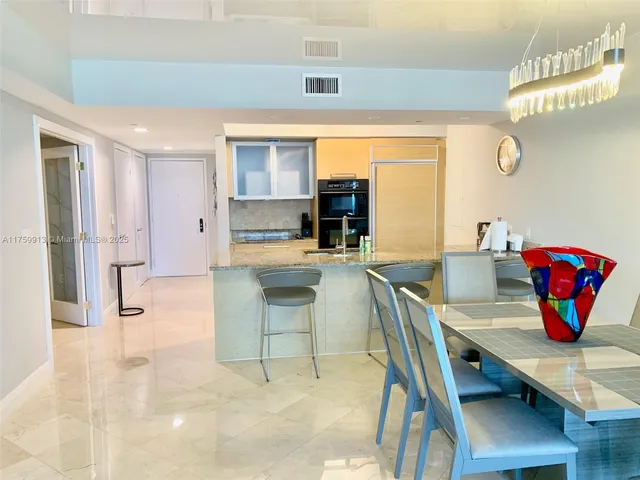 a dining room with furniture and a floor to ceiling window