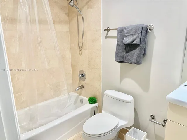 a white toilet sitting next to a bath tub and a shower