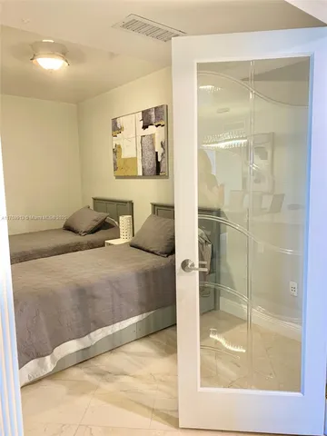 a bedroom with a bed and glass door
