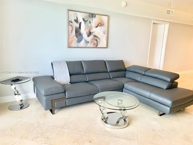 a living room with furniture and a glass door