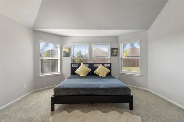 a bed sitting in a bedroom next to a window