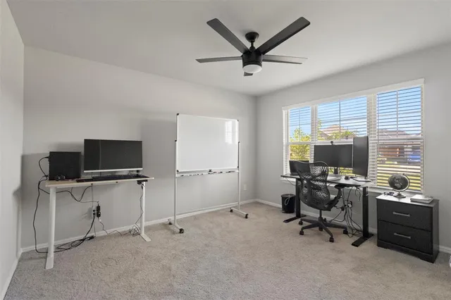 a view of a workspace with furniture and a window