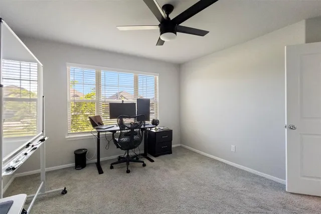 a view of a workspace with furniture and a window