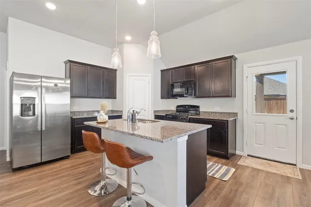 a kitchen with stainless steel appliances granite countertop a sink refrigerator and microwave