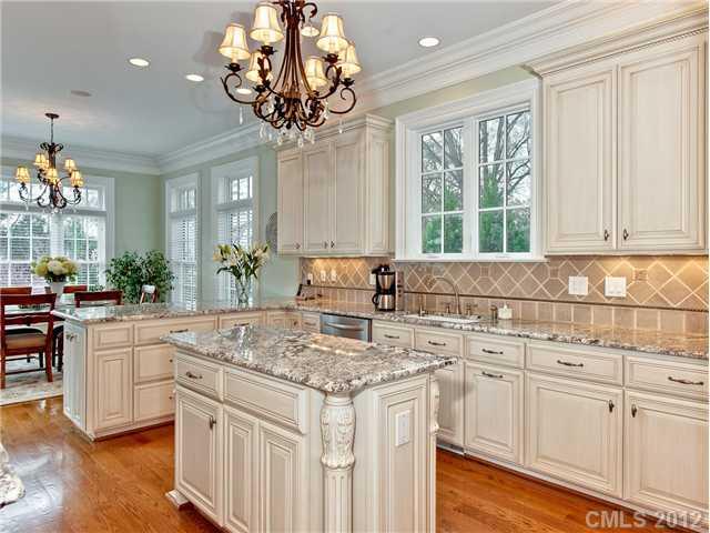 2228 Overhill Road Charlotte, NC 28211 - Photo 7 of 16 a kitchen with white cabinets and chandelier