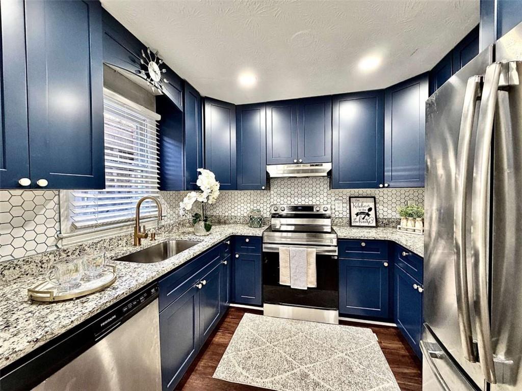 4129 Boxwood Way Duluth, GA 30096 - Photo 7 of 27 a kitchen with stainless steel appliances granite countertop sink stove refrigerator and cabinets