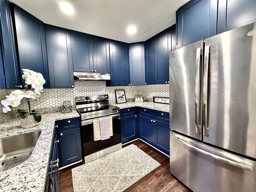 4129 Boxwood Way Duluth, GA 30096 - Photo 9 of 27 a kitchen with granite countertop stainless steel appliances and wooden cabinets