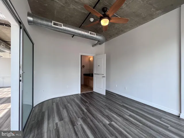 a view of an empty room with wooden floor