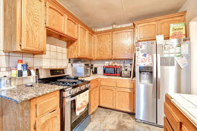 a kitchen with stainless steel appliances granite countertop a refrigerator a stove and a refrigerator