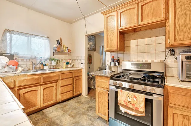 a kitchen with stainless steel appliances granite countertop a stove a sink and a microwave