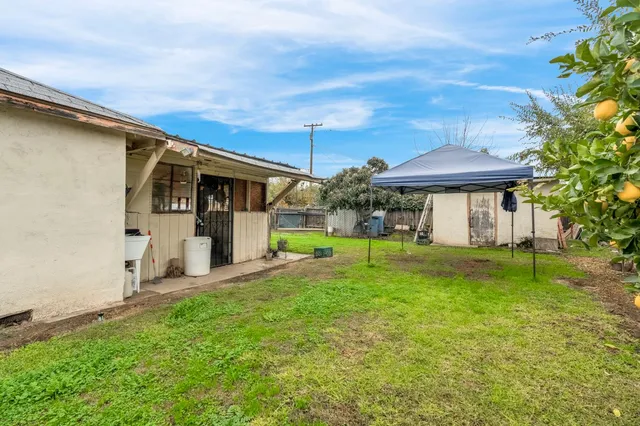 a view of a house with backyard and sitting area