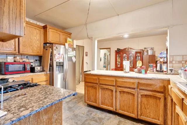 a kitchen with stainless steel appliances granite countertop a refrigerator and stove