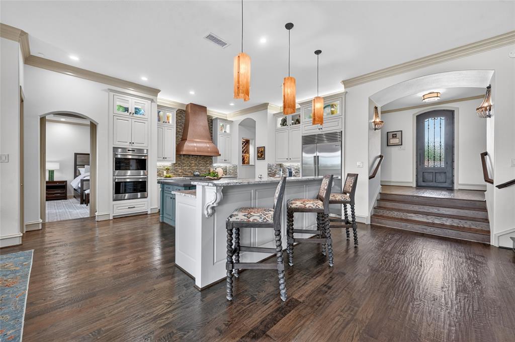 139 Trinity Court Coppell, TX 75019 - Photo 6 of 40 The chef’s kitchen is a modern farmhouse-leaning masterpiece with custom cabinets, granite counters, updated lighting, gorgeous backsplash, and high-end appliances including a built-in Sub-Zero fridge and Wolf six-burner rangetop with double ovens.
