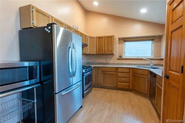 a kitchen with stainless steel appliances granite countertop a refrigerator and a sink