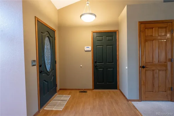 a view of a hallway with wooden floor and closet area